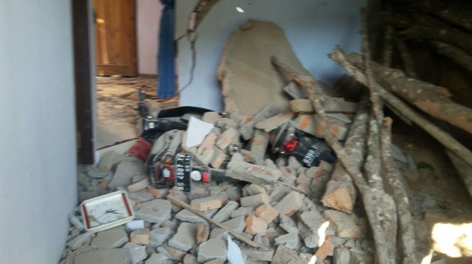 Rumah Sukiyat yang temboknya hancur akibat terkena bus Aneka Jaya. (Foto: Info Trenggalek)