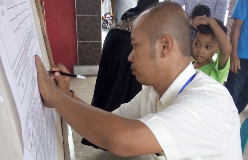 Seorang petugas KPPS sedang menghitung rekapitulasi suara di TPS di Pacitan, Rabu (9/12/2015). (Foto: Nurhadi Yudo/Info Pacitan)
