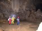 Tiga penjelajah gua lengkap dengan helm dan lampu kepala berdiri di dalam ornamen stalaktit besar Gua Luweng Jaran di Desa Jlubang, Kecamatan Pringkuku, Kabupaten Pacitan.