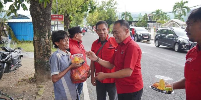 Ketua DPC PDI Perjuangan Pacitan Heru Setyanto membagikan paket sembako dan tumpeng mini kepada pekerja informal di jalanan Pacitan dalam rangka peringatan HUT ke-79 Megawati Soekarnoputri.