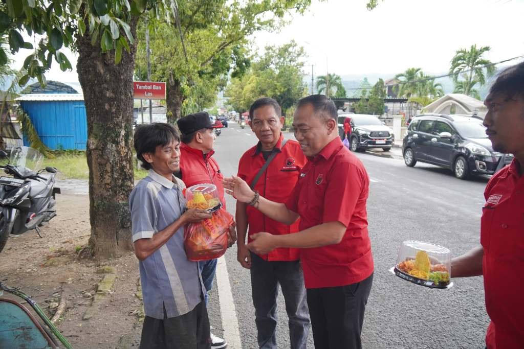 Ketua DPC PDI Perjuangan Pacitan Heru Setyanto membagikan paket sembako dan tumpeng mini kepada pekerja informal di jalanan Pacitan dalam rangka peringatan HUT ke-79 Megawati Soekarnoputri.