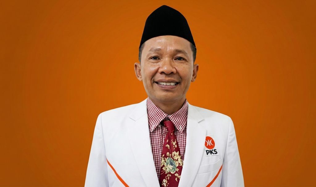 Foto resmi Pujo Hartono, anggota PAW DPRD Pacitan dari PKS, dilantik pada 12 Januari 2026, mengenakan jas putih, dasi batik merah, dan peci hitam dengan latar belakang oranye.