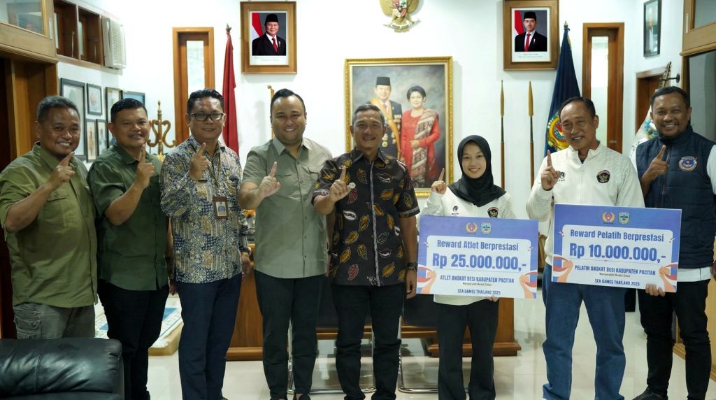 Bupati Pacitan Indrata Nur Bayuaji menyerahkan bonus uang tunai kepada atlet angkat besi Luluk Diana Tri Wijayana.