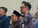 Kepala Dinas Pendidikan Pacitan, Khemal Pandu Pratikna (berkacamata dan memakai batik), berdiri di samping Pengasuh Ponpes Tremas, Kiai Luqman Harist Dimyathi (memakai peci hitam), dalam acara sosialisasi SSN.