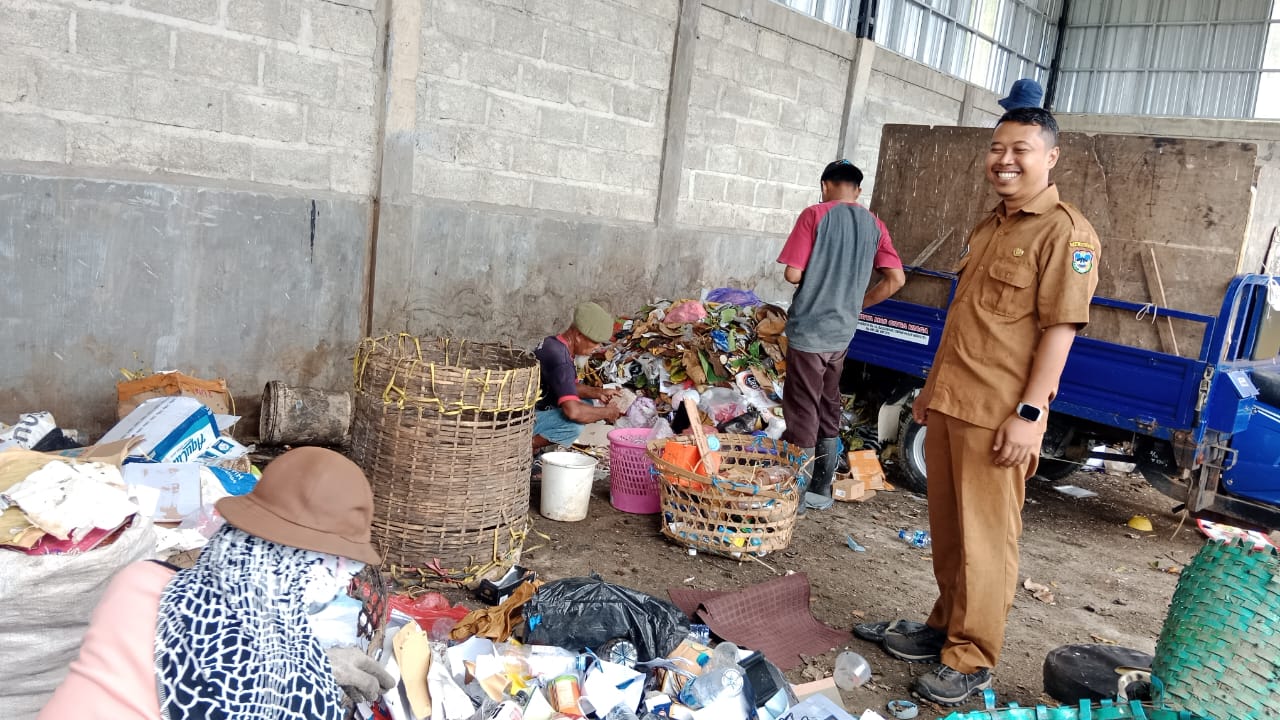 Pekerja di TPS 3R Pace Sewu Kelurahan Pacitan sedang memilah dan mengolah sampah menggunakan mesin pencacah.