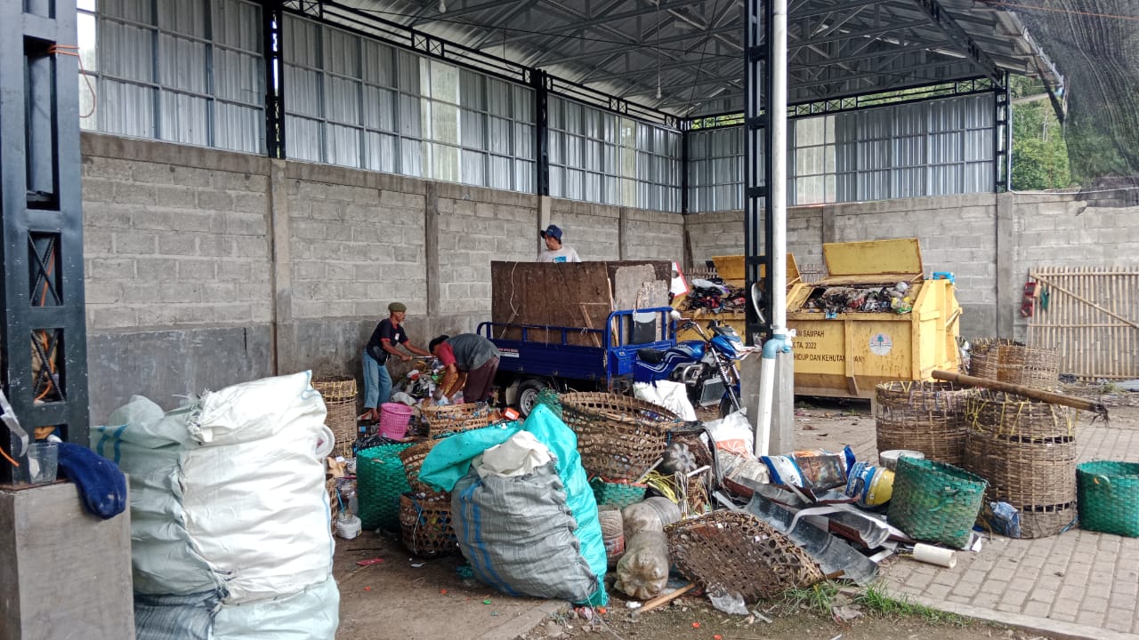 Bangunan gedung TPS 3R Pace Sewu dan kendaraan bermotor pengangkut sampah yang parkir di depannya.