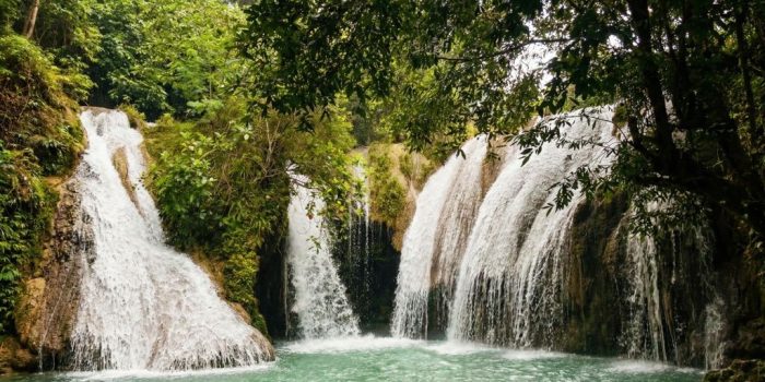Pemandangan air terjun Grojogan Duwur yang menjulang tinggi di Desa Candi, Pacitan, dengan suasana alam yang asri.