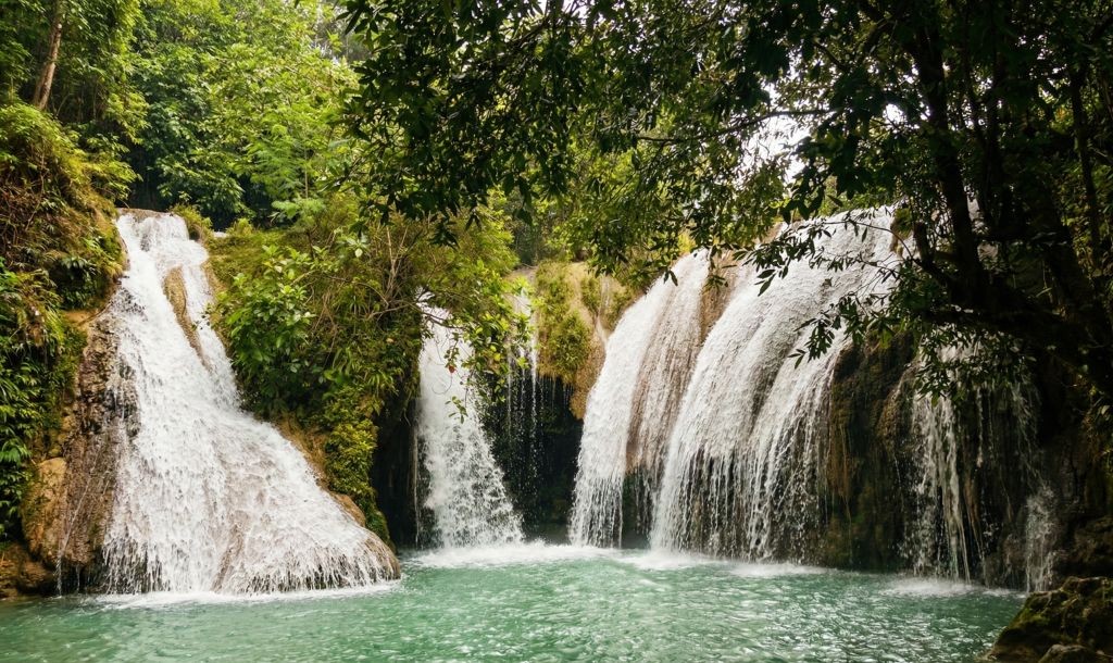 Pemandangan air terjun Grojogan Duwur yang menjulang tinggi di Desa Candi, Pacitan, dengan suasana alam yang asri.