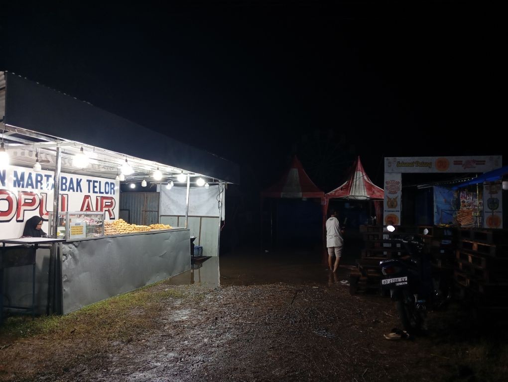 Kondisi Pasar Malam Lapangan Auri Pacitan yang terendam banjir setinggi betis hingga lutut orang dewasa.