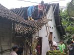 Warga dan petugas bekerja bakti memperbaiki atap rumah yang rusak akibat gempa di Desa Kedungbendo, Pacitan.