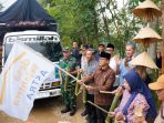 Menteri Desa PDT Yandri Susanto (berbatik cokelat di tengah) bersama Bupati Pacitan dan pejabat lainnya memegang kentongan bambu dalam seremoni pelepasan ekspor perdana gula aren Desa Sejahtera Astra Temon, Pacitan, di depan truk pengangkut berstiker "bismillah".