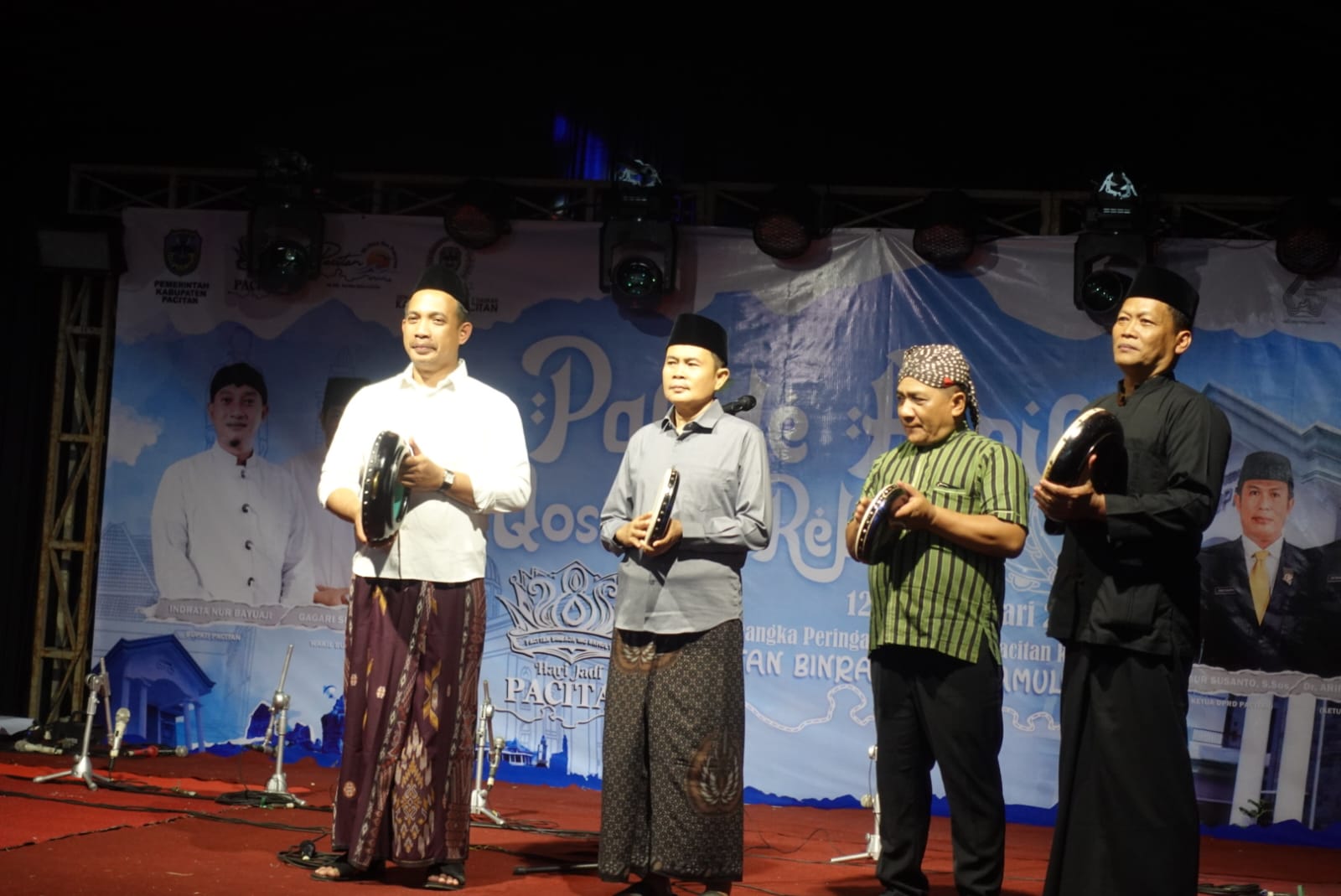 Empat pria berpakaian tradisional Jawa dan peci, termasuk Ketua DPRD Pacitan Arif Setia Budi, berdiri di atas panggung sambil memegang rebana. Mereka berada di depan spanduk besar bertuliskan "Pacitan Binraja Ing Kamulyan" dan "Hari Jadi Pacitan ke-281" saat pembukaan Festival Rebana.
