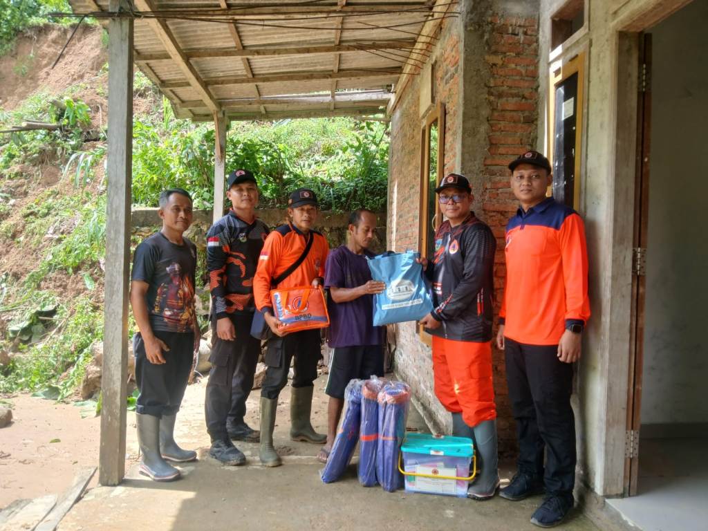 Petugas BPBD Pacitan menyalurkan bantuan logistik darurat kepada warga terdampak bencana tanah longsor di Kecamatan Sudimoro.