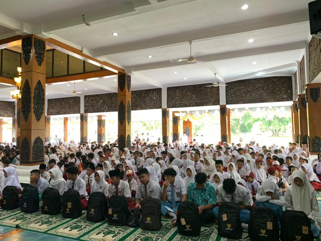 Anak yatim di Kabupaten Pacitan tersenyum bahagia memegang tas baru dan santunan bantuan pendidikan dari BAZNAS. (Foto: Tatik Dwi Astuti/Pacitanku)