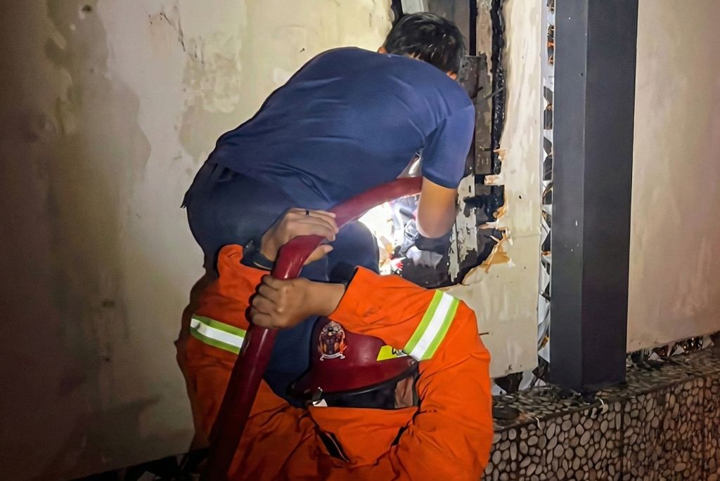 Petugas Damkar Pacitan sedang melakukan proses pendinginan di lokasi kebakaran Graha Prima Bar dan Karaoke.