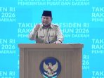 Presiden Prabowo Subianto, mengenakan seragam dinas harian berwarna cokelat dan peci hitam, berbicara di mimbar berlogo Garuda Pancasila saat mencanangkan proyek gentengisasi nasional dalam Rapat Koordinasi Nasional (Rakornas) Pemerintah Pusat dan Daerah Tahun 2026 di Sentul, Senin (2/2/2026). Latar belakang menunjukkan tulisan "RAKORNAS TAHUN 2026" dan "PEMERINTAH PUSAT DAN DAERAH".