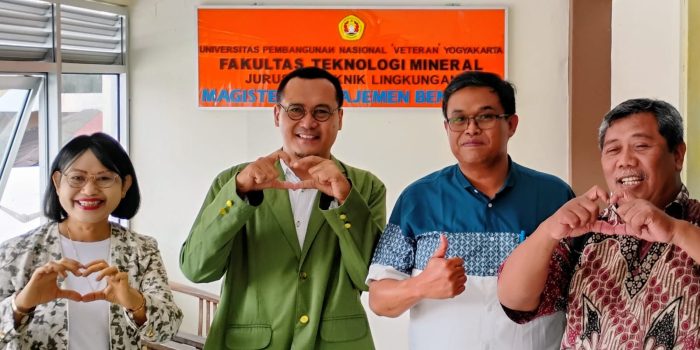 Sebuah foto kelompok berisi empat orang, termasuk Purwoto yang mengenakan jas almamater hijau, bersama tiga dosen pembimbingnya di depan spanduk oranye bertuliskan "UNIVERSITAS PEMBANGUNAN NASIONAL 'VETERAN' YOGYAKARTA FAKULTAS TEKNOLOGI MINERAL JURUSAN TEKNIK LINGKUNGAN MAGISTER MANAJEMEN BENCANA". Mereka berpose dengan senyum, beberapa membentuk simbol hati dengan tangan dan satu orang mengacungkan jempol.