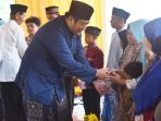 Wakil Bupati Pacitan Gagarin Sumrambah menyerahkan santunan kepada anak yatim di Masjid Baiturrohman Watupatok.