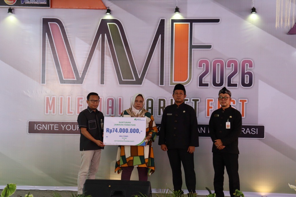 Kepala BPJS Ketenagakerjaan Pacitan bersama pejabat daerah menyerahkan papan simbolis santunan kematian sebesar Rp74 juta kepada ahli waris almarhum Mulyono di acara Milenial Market Fest.
