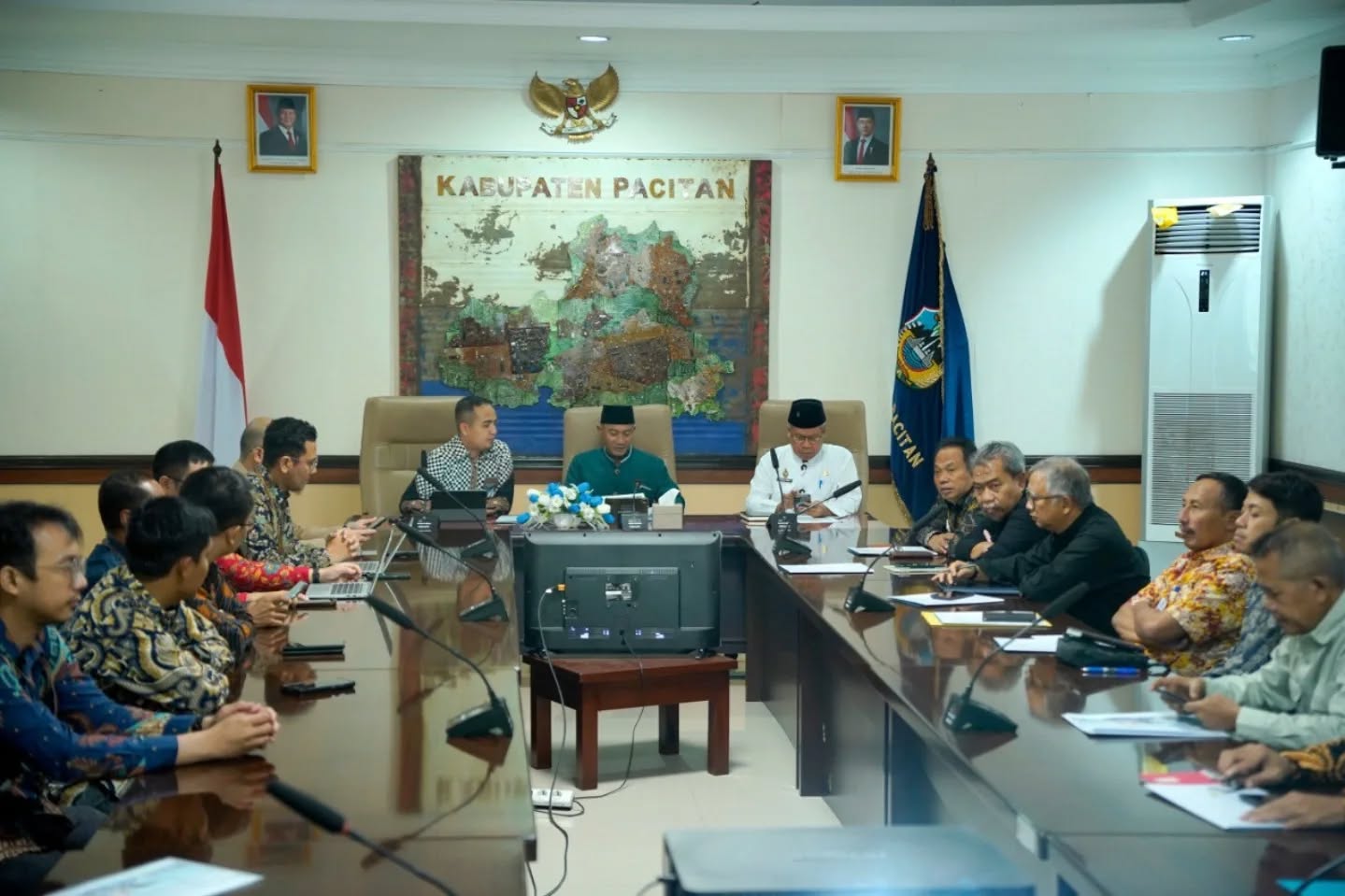 Jajaran manajemen PT PLN (Persero) sedang duduk berbincang dan memaparkan dokumen kepada Bupati Pacitan Indrata Nur Bayuaji di dalam ruang kerja bupati.