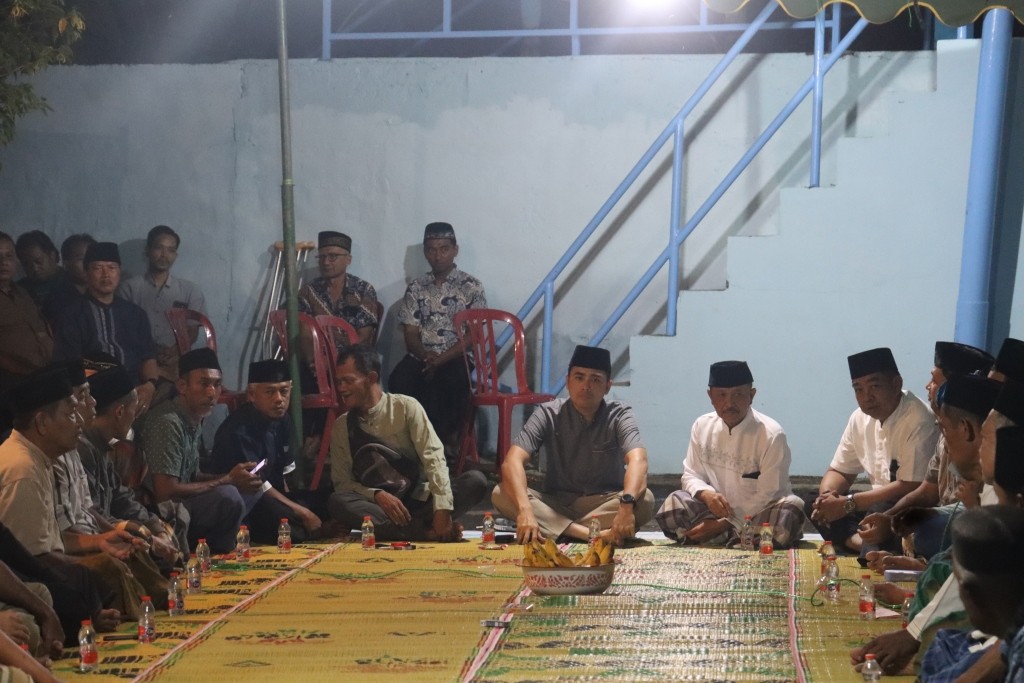 Kapolres Pacitan AKBP Ayub Diponegoro Azhar duduk lesehan mengikuti doa bersama warga di lokasi kecelakaan Desa Arjowinangun.