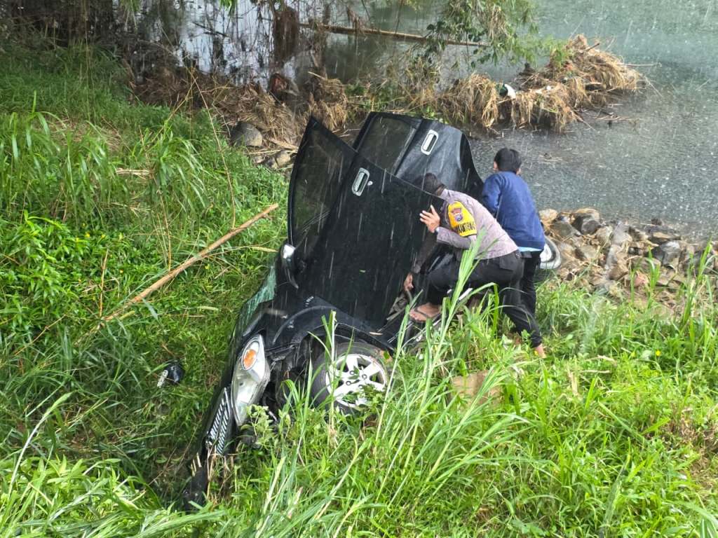 Mobil Avanza warna hitam terperosok ke dalam sungai di Arjosari Pacitan akibat kecelakaan lalu lintas.