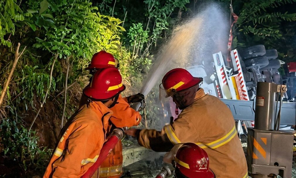 Personel Damkar Pacitan melakukan pendinginan pada truk tangki BBM yang terguling di Jalur Pacitan-Solo.