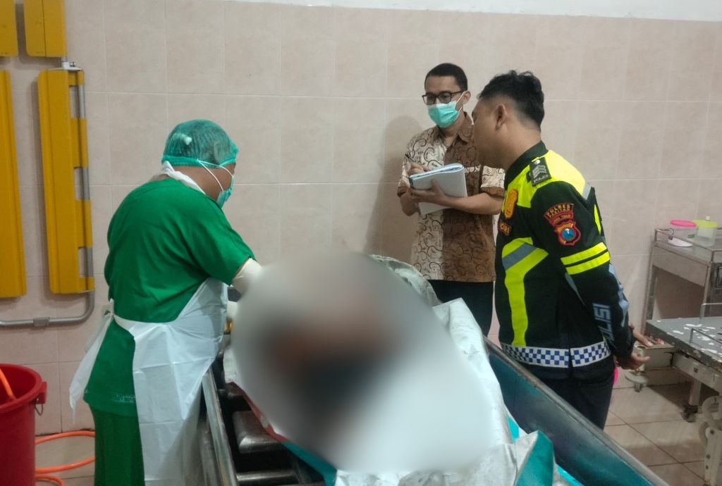 Petugas medis Puskesmas Ngadirojo sedang melakukan proses identifikasi dan pemeriksaan awal pada jenazah korban kecelakaan tabrak lari di Pacitan.