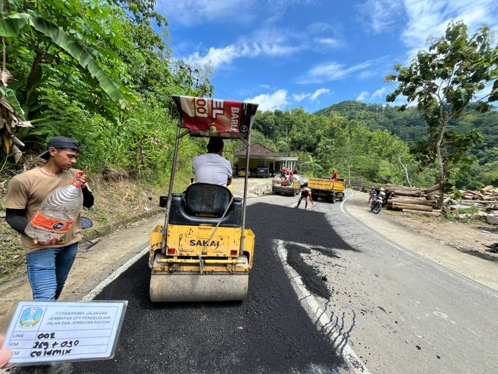 Petugas UPT PJJ Bina Marga Jatim menyiagakan alat berat loader di pinggir jalan raya Pacitan yang berbatasan dengan tebing.