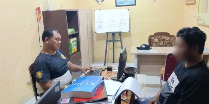 Personel Polsek Pacitan mengamankan pelaku pencurian uang di Toko LA Mart beserta barang bukti sepeda motor Scoopy.