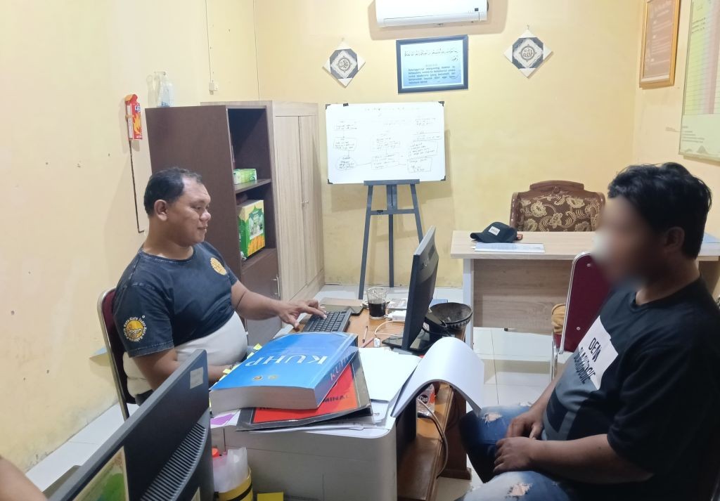 Personel Polsek Pacitan mengamankan pelaku pencurian uang di Toko LA Mart beserta barang bukti sepeda motor Scoopy.