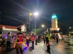 Aparat keamanan gabungan bersiaga mengawal ratusan warga yang memainkan musik rontek bambu di jalanan Kabupaten Pacitan.