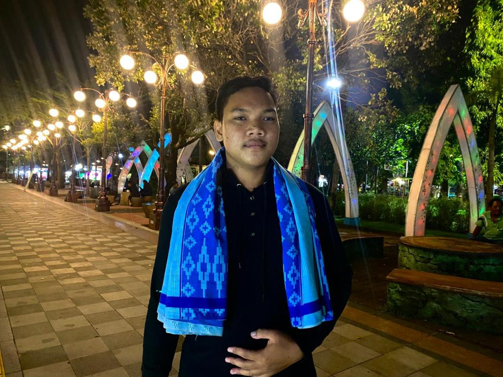 Muhamat Andika, warga Pacitan, memberikan keterangan mengenai semangat tradisi Rontek Gugah Sahur di tengah gerimis.