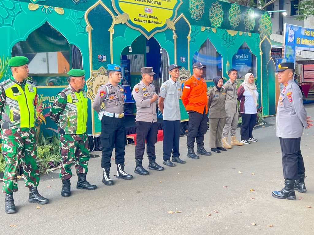 Anggota Polres Pacitan dan Dinas Perhubungan (Dishub) melakukan briefing dan koordinasi di depan Pos Pelayanan Alun-alun Pacitan sebelum bertugas mengamankan puncak arus balik Lebaran 2026.