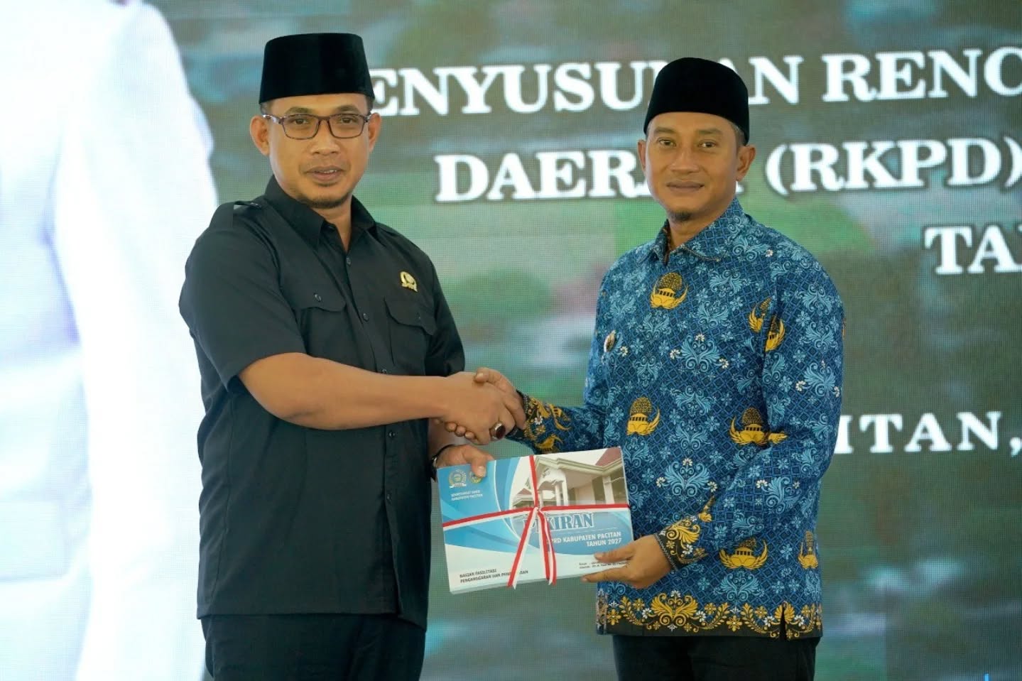 Foto Ketua DPRD Kabupaten Pacitan menyerahkan dokumen map berisi naskah RKPD 2027 kepada Bupati Pacitan Indrata Nur Bayuaji di atas panggung Pendopo Kabupaten.
