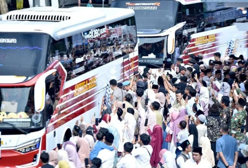Jemaah calon haji asal Pacitan berseragam batik haji berjalan memasuki bus diiringi isak tangis dan lambaian tangan dari keluarga pengantar.