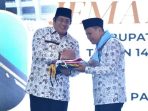 Wakil Bupati Pacitan Gagarin Sumrambah melambaikan tangan saat melepas armada bus jemaah calon haji di halaman Pendopo Kabupaten Pacitan.