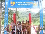 Kapolres Pacitan AKBP Ayub Diponegoro Azhar memotong pita saat meresmikan Jembatan Presisi Merah Putih di Desa Mangunharjo, Arjosari.
