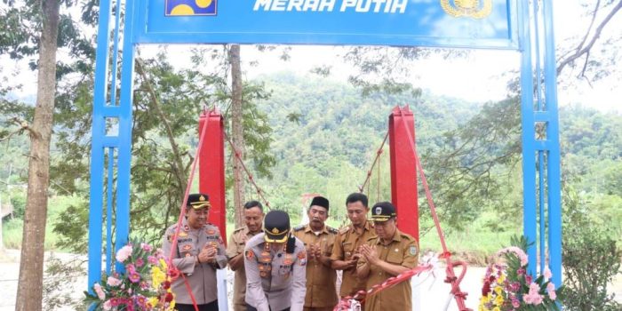 Kapolres Pacitan AKBP Ayub Diponegoro Azhar memotong pita saat meresmikan Jembatan Presisi Merah Putih di Desa Mangunharjo, Arjosari.