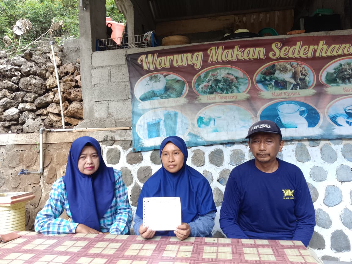 Pria paruh baya bernama Kateni, ahli waris lahan Goa Gong, menunjukkan dokumen lawas bukti kepemilikan tanah di depan pintu masuk wisata Goa Gong, Pacitan.