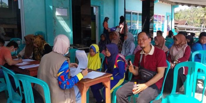 Seorang dokter gigi spesialis sedang memeriksa gigi seorang pasien warga Desa Poko menggunakan peralatan medis, fokus pada interaksi medis.