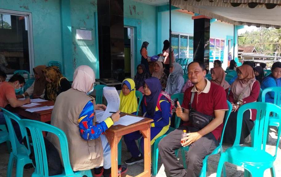 Seorang dokter gigi spesialis sedang memeriksa gigi seorang pasien warga Desa Poko menggunakan peralatan medis, fokus pada interaksi medis.