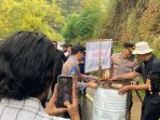 Wakil Gubernur Jawa Timur Emil Dardak dan Kapolres Pacitan AKBP Ayub memindahkan drum barikade dari tengah jalan provinsi di Tegalombo.