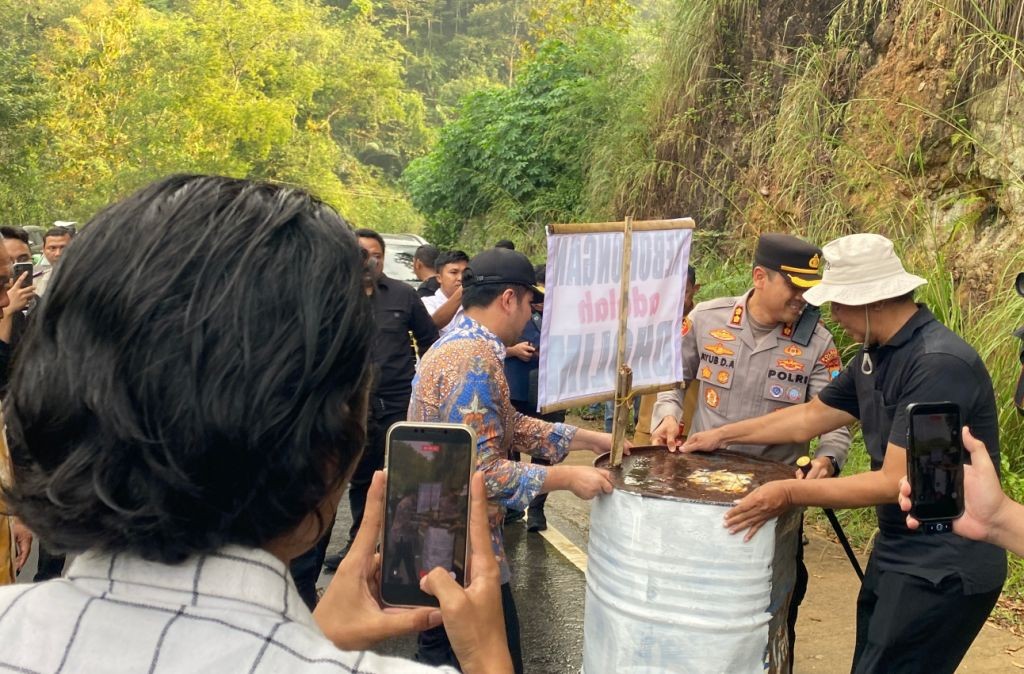 Wakil Gubernur Jawa Timur Emil Dardak dan Kapolres Pacitan AKBP Ayub memindahkan drum barikade dari tengah jalan provinsi di Tegalombo.