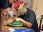 Petugas Damkar Pacitan memotong cincin macet di jari lansia menggunakan gerinda mini didampingi tim PSC 119.