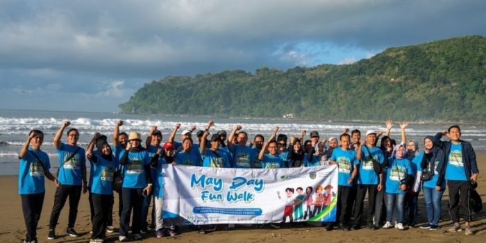 Peserta fun walk May Day 2026 BPJS Ketenagakerjaan Pacitan berjalan menyusuri Pantai Parai Teleng Ria bersama perwakilan perusahaan dan Pemkab Pacitan.