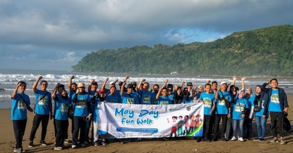 Peserta fun walk May Day 2026 BPJS Ketenagakerjaan Pacitan berjalan menyusuri Pantai Parai Teleng Ria bersama perwakilan perusahaan dan Pemkab Pacitan.