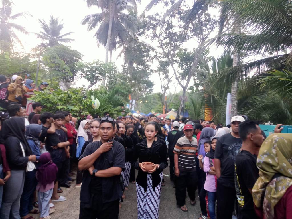 Warga saling lempar kelapa muda dalam puncak tradisi Ceprotan di Desa Sekar Pacitan.