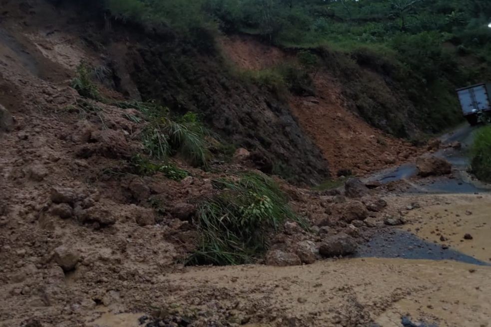 Material tanah basah dan bebatuan menutup total akses jalan kabupaten di Dusun Sidodadi, Bandar, Pacitan akibat tanah longsor.