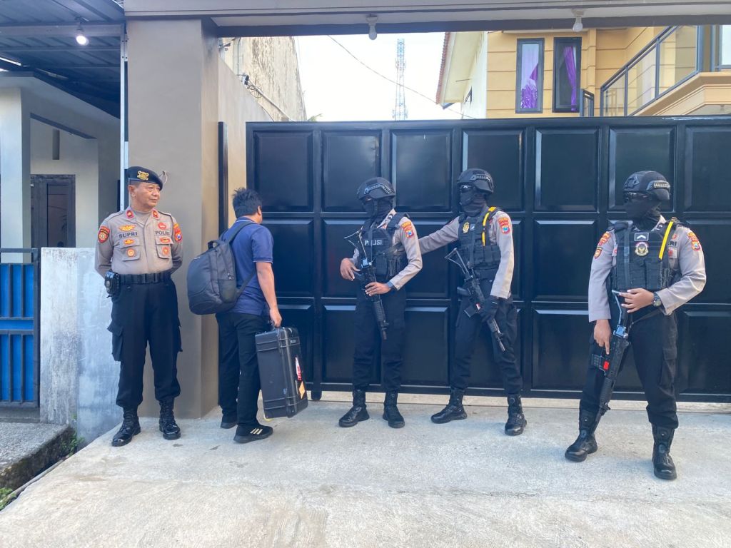 Polisi bersenjata laras panjang berjaga di depan rumah mewah yang digeledah KPK di Pacitan.